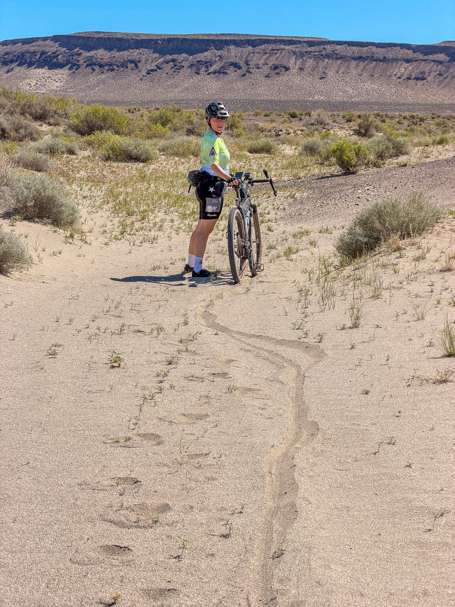 Amy pushing bike through deep sand in Little Sand Gap