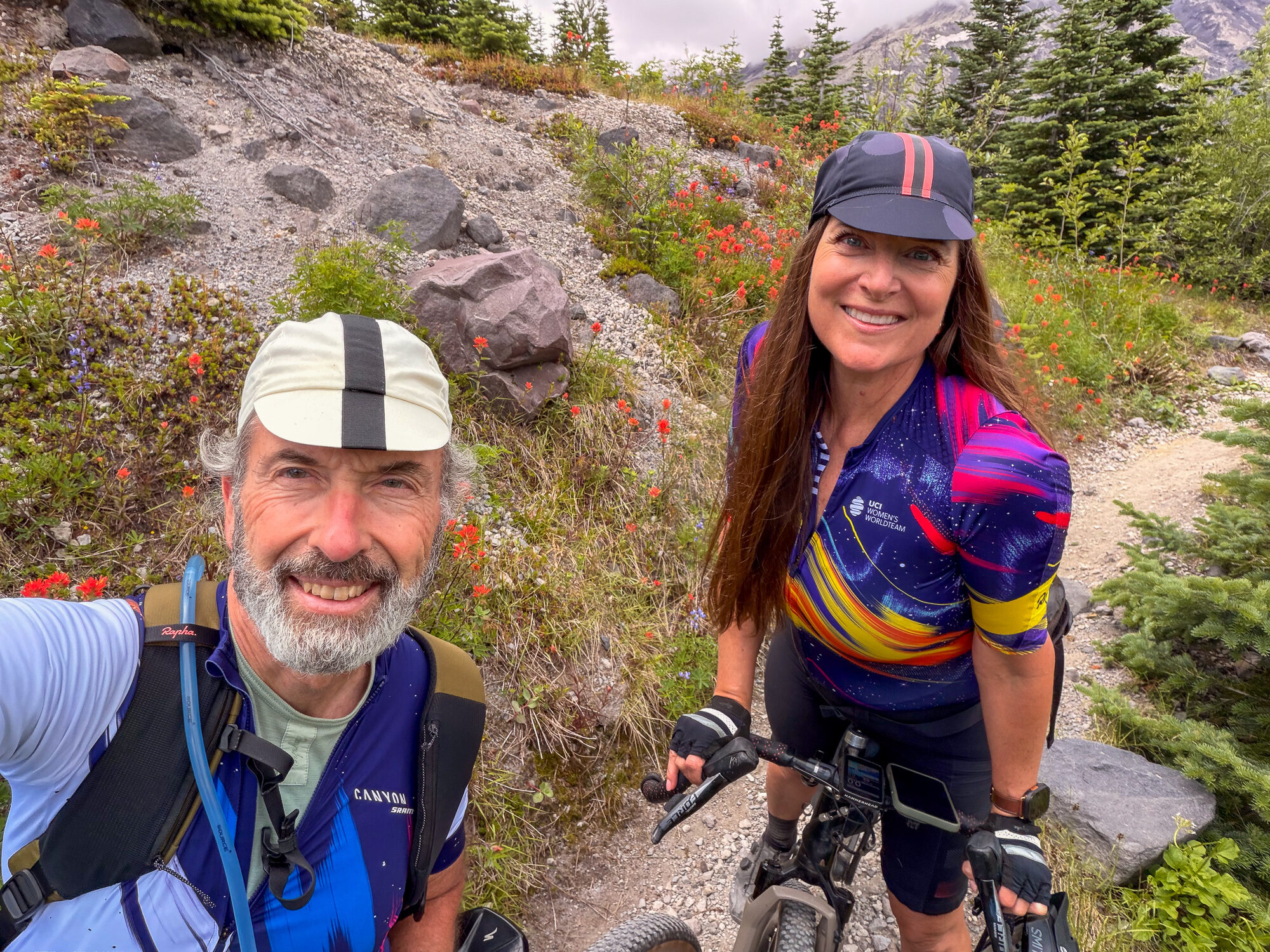 James and Amy smiling together beside their bikes on the trail