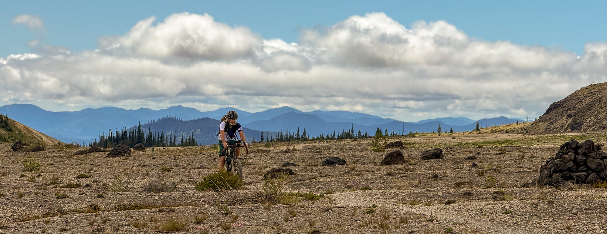 A rider crossing the wide open Plains of Abraham with distant ranges under a big sky