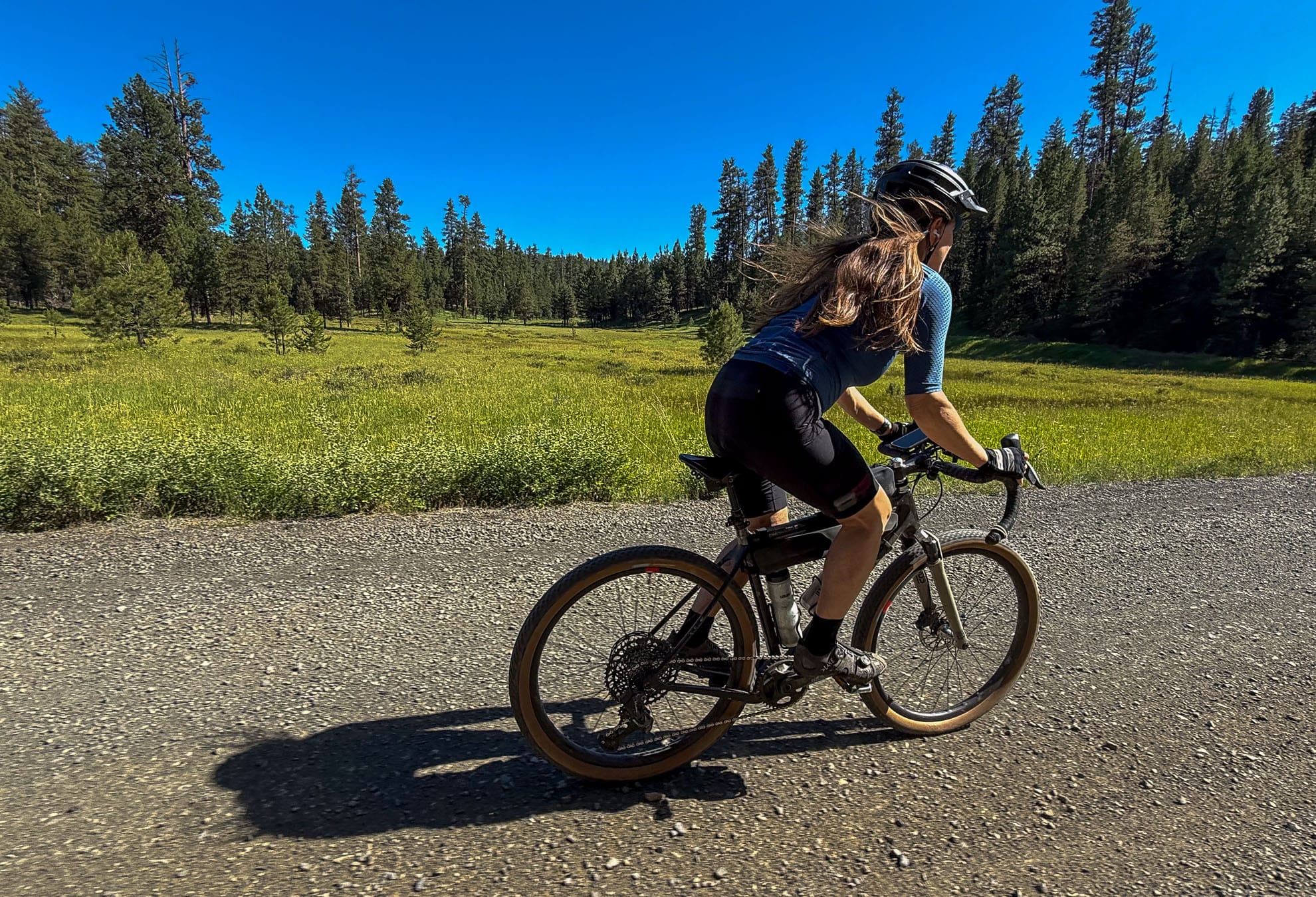 Women cycling fast on a gravel road.
